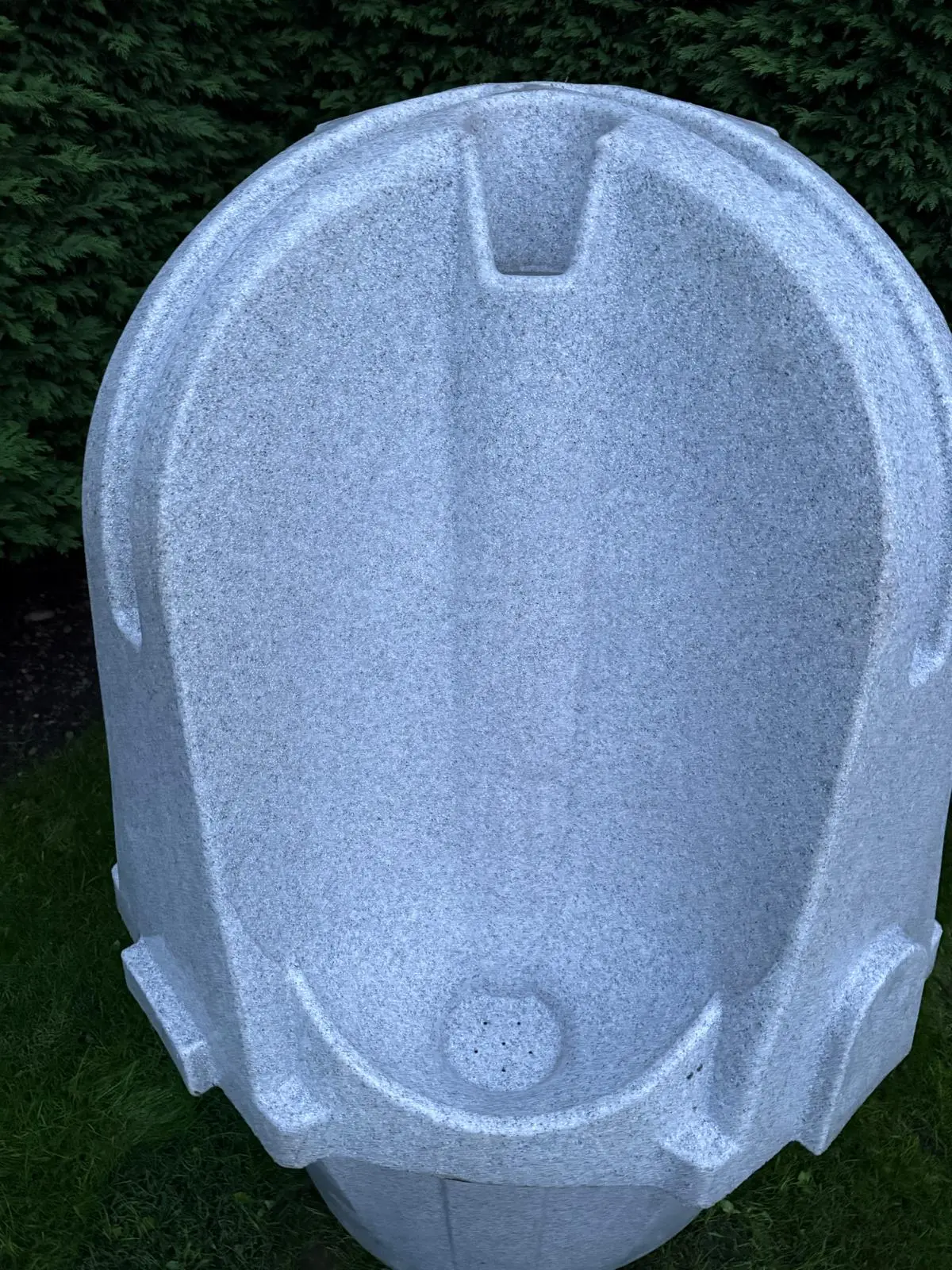 Top-down close-up of a grey portable urinal unit basin