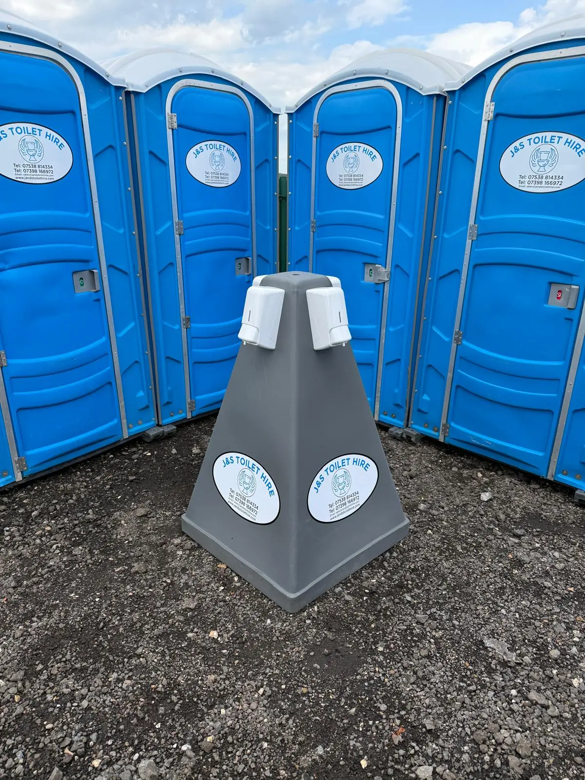 Wash station surrounded by blue portable toilets at a site