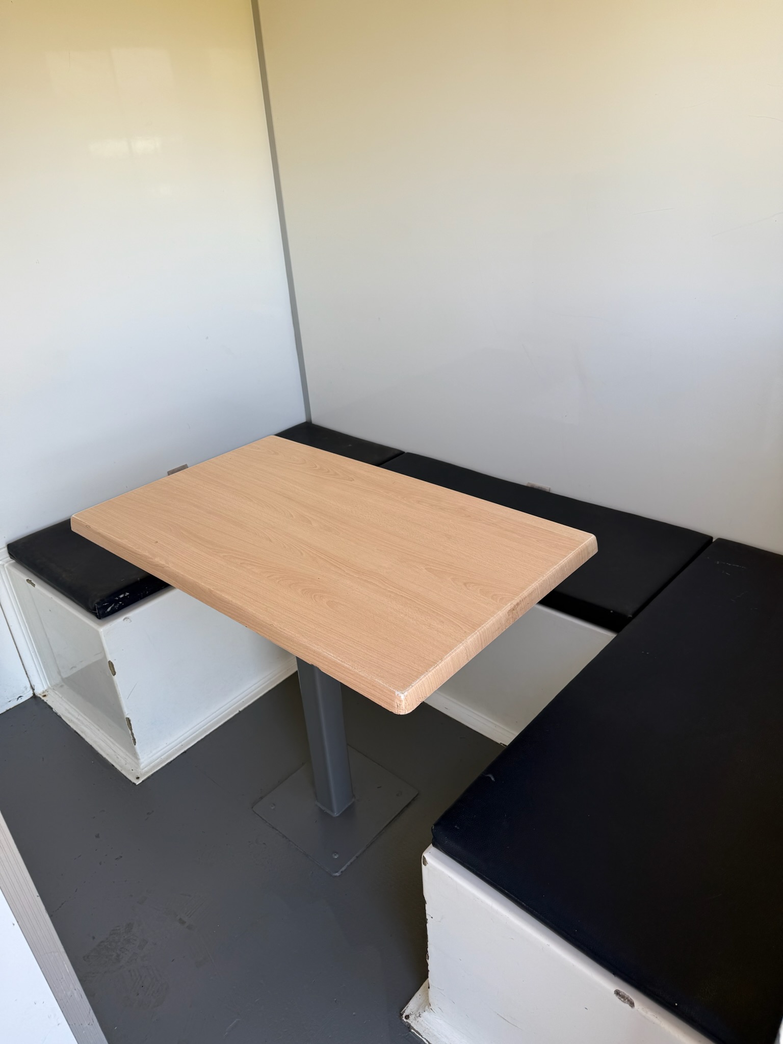 Welfare unit interior - seating area with wooden table and bench