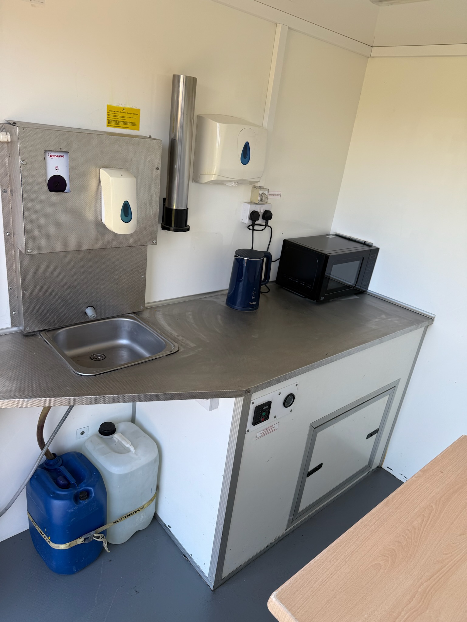 Welfare unit interior - kitchen area with sink, microwave and storage